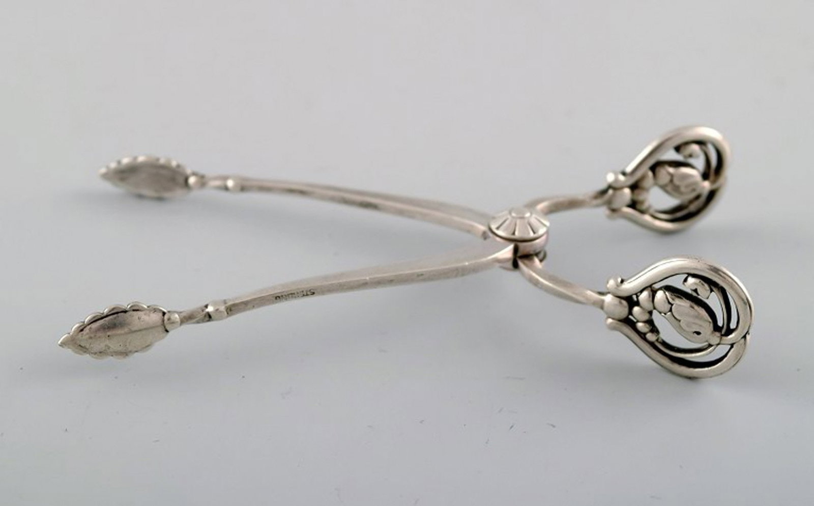 Georg Jensen sugar tang in sterling silver, 'blossom'.: Title:Georg Jensen sugar tang in sterling silver, 'blossom'. Description:Georg Jensen sugar tang in sterling silver, 'Blossom'. Produced 1925 - 1932. In perfect condition. Hallmarked. Measures 9,7 cm.