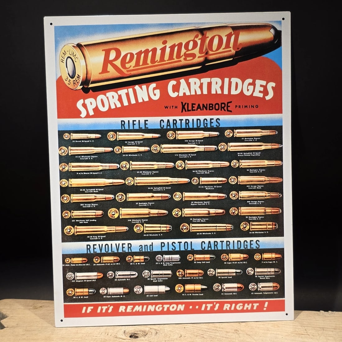 Remington Sporting Cartridges Tin Sign - Rifle Pistol Ammunition Advertising: 16" x 12 1/2" Reproduction Remington Sporting Cartridges advertising sign featuring a slightly blurry display of rifle, revolver, and pistol cartridge types, styled after early 20th-century