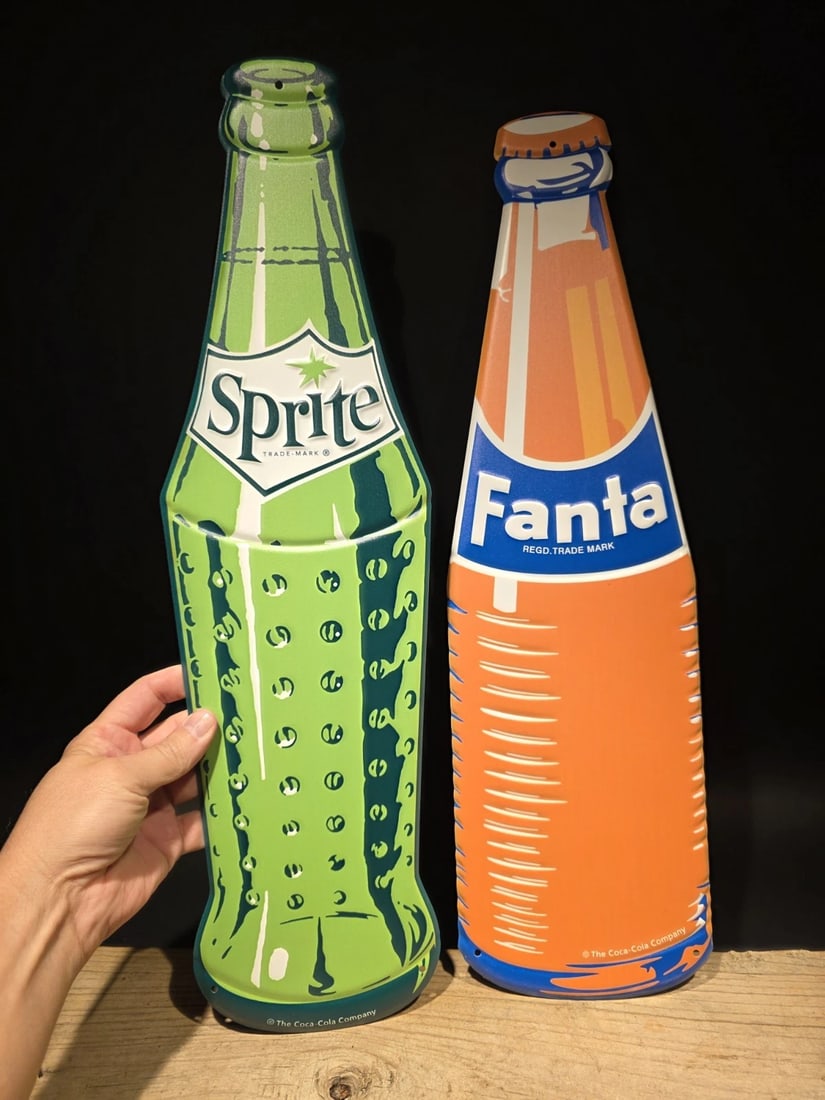 22" Vintage Style Metal Die Sprite & Fanta Bottle Signs Collection: Both are 22" Long x 6" Wonderful reproduction Sprite and Fanta signs. Good detail styled to look vintage. Certainly hard to tell its age. Reserve: $44.00 Shipping: Domestic: Flat-rate of $8.00 to
