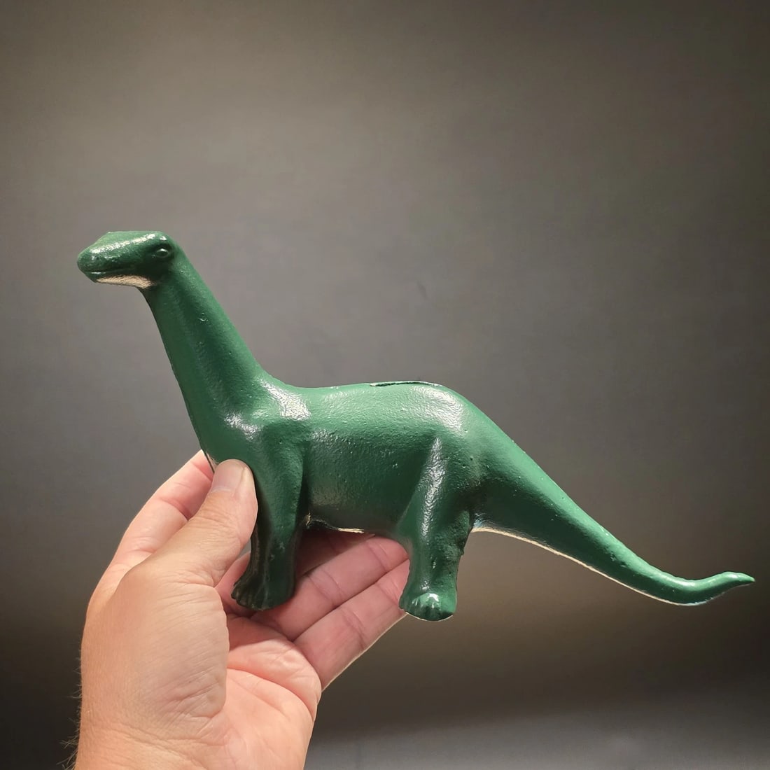 Cast Iron Brontosaurus Dinosaur Coin Bank: Reproduction cast iron dinosaur coin bank in the style of the classic Sinclair Oil Brontosaurus mascot, often known as "Dino." Sinclair introduced the green dinosaur as part of its petroleum