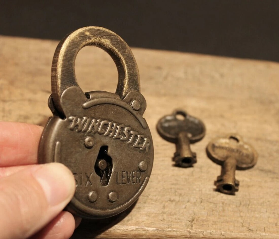 Cast Iron Winchester Firearms Ammo Box Padlock Lock & Key: 3" tall x 2" Wide the shank is 3/8" at its thickest Nice reproduction cast iron winchester padlock! This lock is fully functional! Hard to tell its age. Heavy iron and brass. Great aged patina through