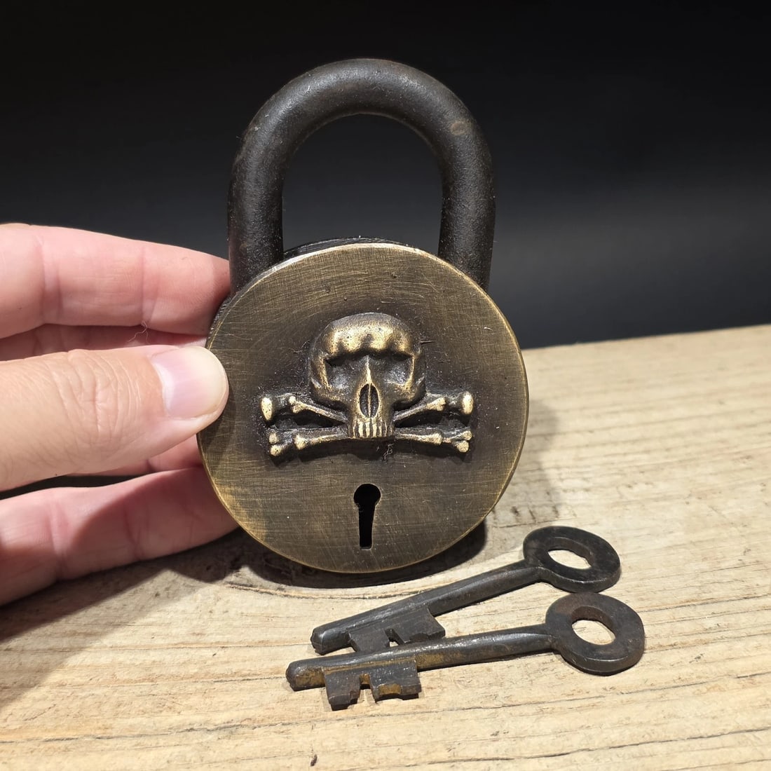 Wrought Iron & Brass Pirate Skull Crossbones Bridge Padlock Lock: Reproduction functional decorative padlock featuring a raised skull and crossbones emblem, styled after traditional pirate and maritime imagery. Symbols like the skull and crossbones became closely as