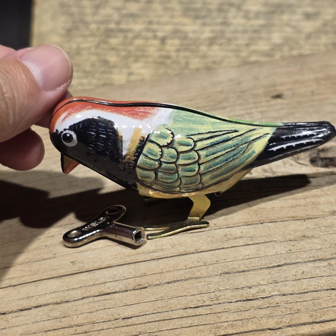 Tin Litho Pecking Bird Toy Wind-Up Mechanical Songbird: Reproduction Vintage-style tin lithograph bird toy featuring colorful printed feather details and a wind-up mechanism. Mechanical bird toys were popular throughout the mid-20th century, especially