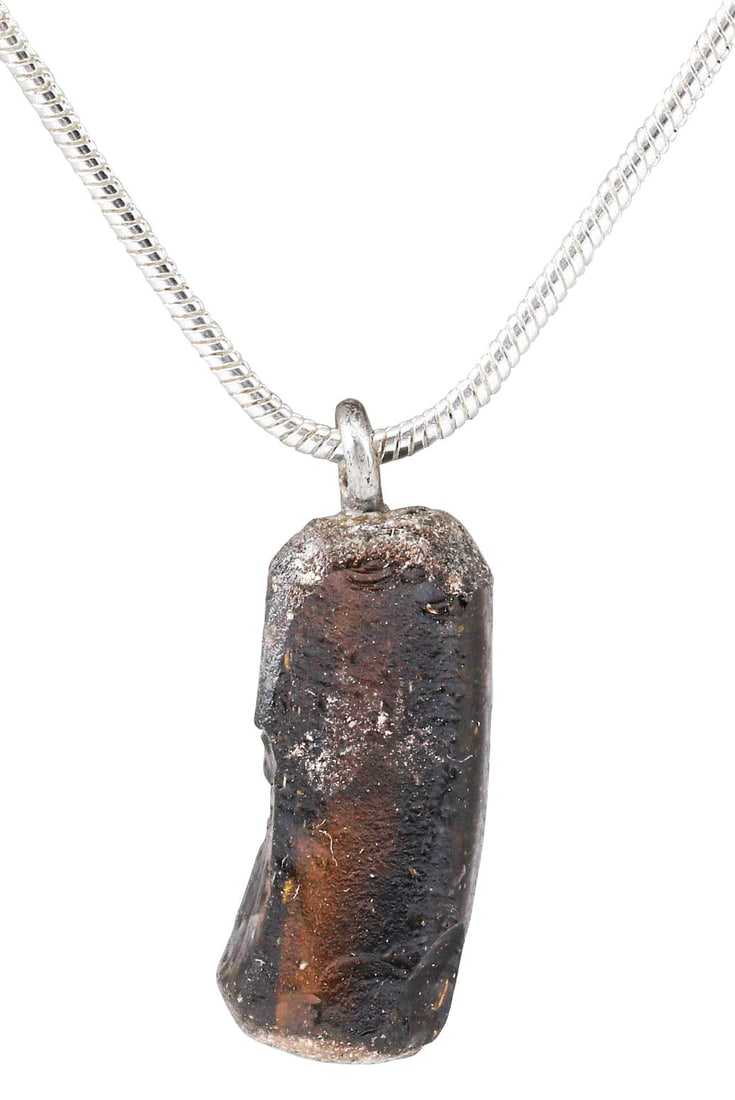 ROMAN GLASS BRACELET SEGMENT C.100-400 AD: A short segment of a Roman woman's glass bracelet of the late Imperial period. About 3/4" length of dark amber hand wound glass. Suspended from an 18" Sterling silver neck chain for modern wear. Gift 