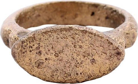 ROMAN WOMAN'S RING 200-450 AD SIZE 2 1/2: Gilt bronze, a little over size 2 1/2 with 3.3mm ridged face band, thickened at the bottom in the Roman taste and stepped shoulders. The raised lenticular bezel with remnants of incising, probably ser