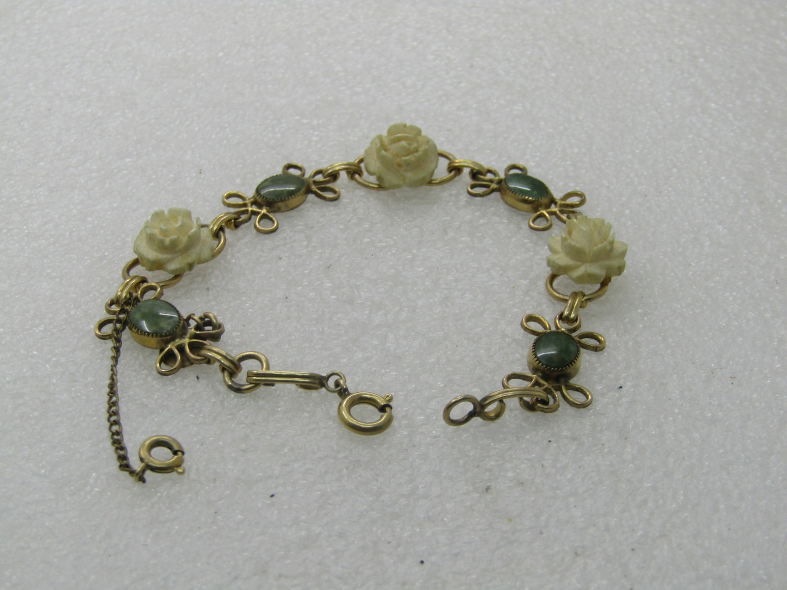 Vintage D'or Faux Carved Rose Bracelet with Green Stones, 7.5" - scrolled accent on each side of the: Title: Vintage D'or Faux Carved Rose Bracelet with Green Stones, 7.5" - scrolled accent on each side of the oval green stones with a raised faux carved white rose . Mid-Century, signed with tag 1/20 1