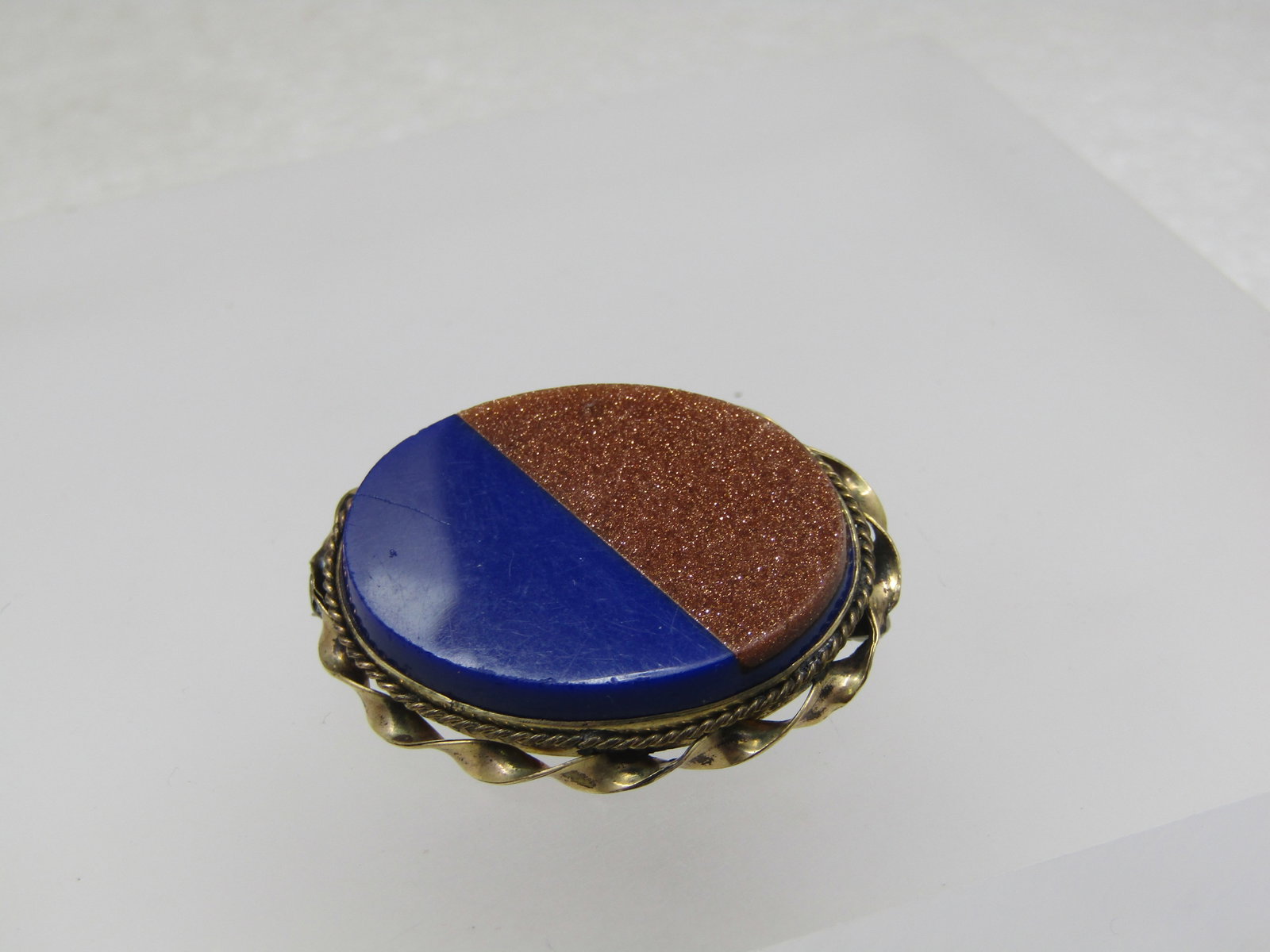 Vintage 12kt G.F. Gold Stone and Blue Stone Brooch, 1950's-1960's: Title: Vintage 12kt G.F. Gold Stone and Blue Stone Brooch, 1950's-1960's Description: Vintage 12kt G.F. Gold Stone and Blue Stone Brooch, 1950's-1960's. Oval brooch with a twisted lower frame and then
