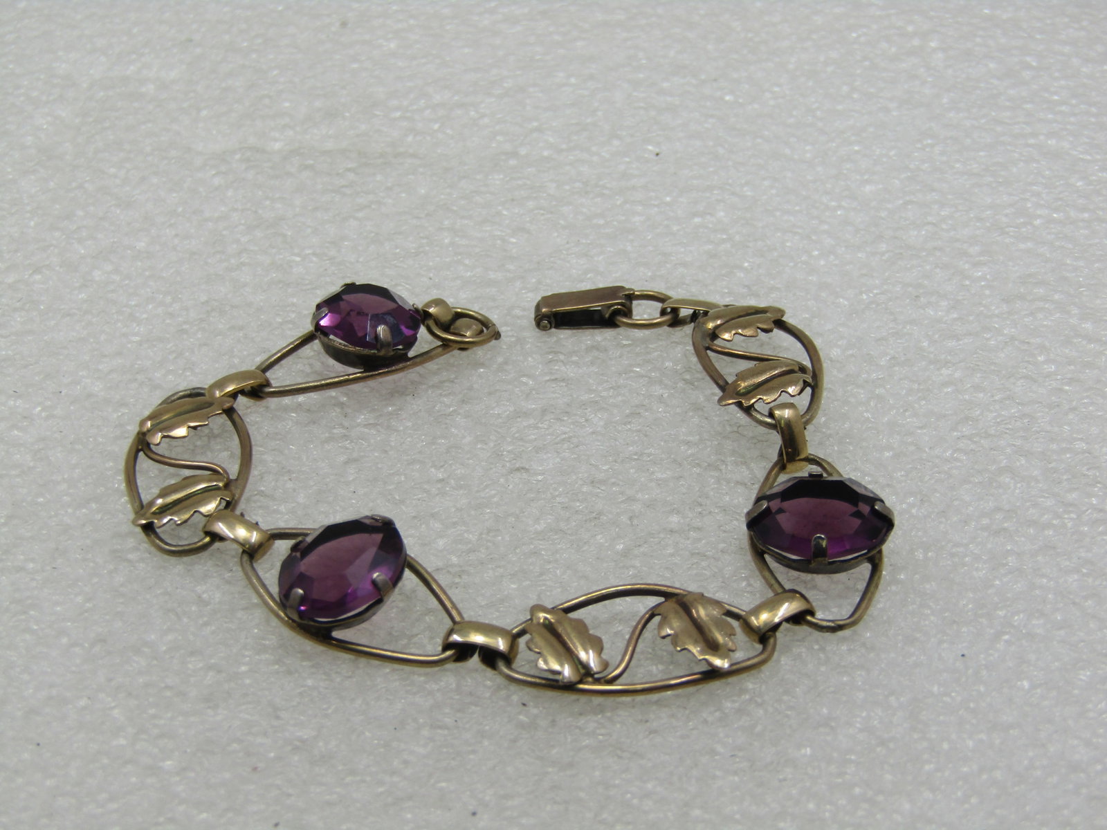Vintage 12kt GF Purple Rhinestone Leaf Bracelet, 7.25", 1940's: Title: Vintage 12kt GF Purple Rhinestone Leaf Bracelet, 7.25", 1940's Description: Vintage 12kt GF Purple Rhinestone Leaf Bracelet, 7.25", 1940's. Six 1" by 1/2" cateye shaped open links with an 11.5m
