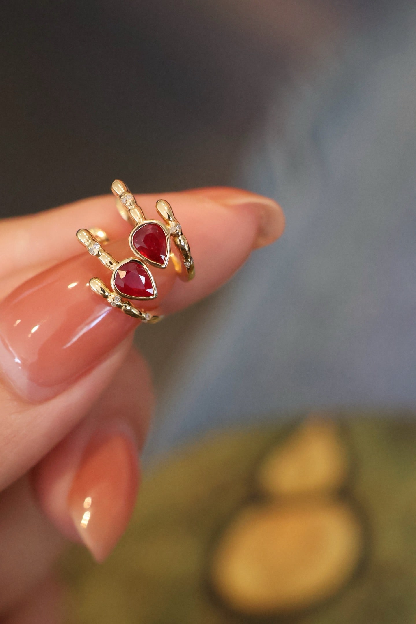 18K Natural Ruby Earrings: Title: 18K Natural Ruby Earrings Description: These earrings are meticulously crafted from 18K gold, featuring a soft luster. The teardrop-shaped natural ruby is gently encased, surrounded by