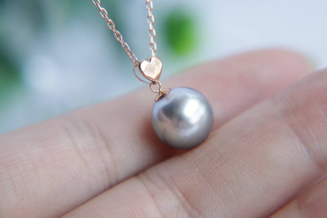18K Gold Flawless Tahitian Sea Pearl Pendant: Title: 18K Gold Flawless Tahitian Sea Pearl Pendant Description: This pendant is meticulously crafted from 18K gold, featuring a flawless Tahitian sea pearl with a diameter of 10mm, showcasing