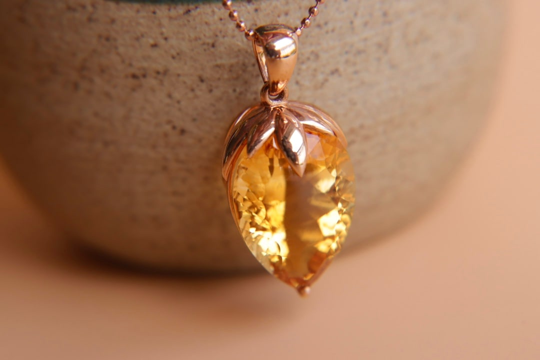 18K Gold Natural Yellow Crystal Pendant: Title: 18K Gold Natural Yellow Crystal Pendant Description: This 18K gold pendant features a 10.84-carat natural yellow crystal, showcasing its unique millennium cut craftsmanship and captivating colo