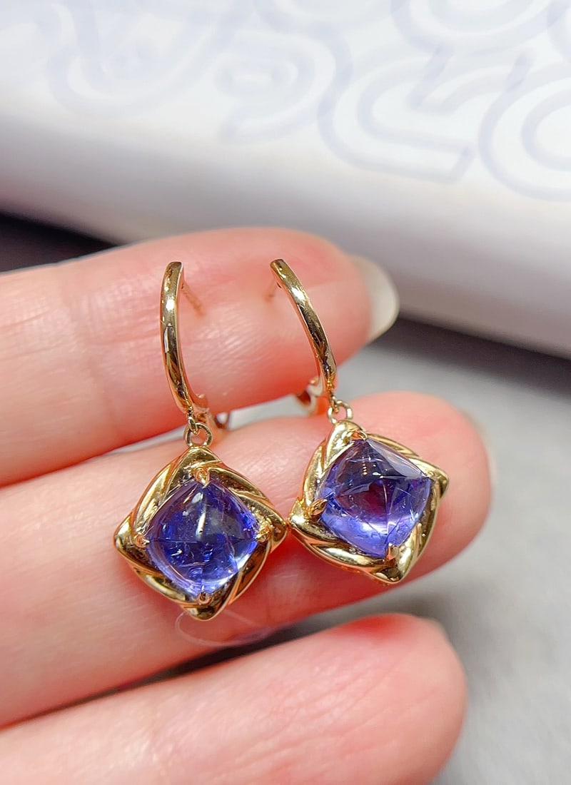 18K Gold Natural Tanzanite Earrings: Title: 18K Gold Natural Tanzanite Earrings Description: These earrings showcase the unique charm of tanzanite with a distinctive sugar tower cut, while the minimalist gold design adds elegance. Main