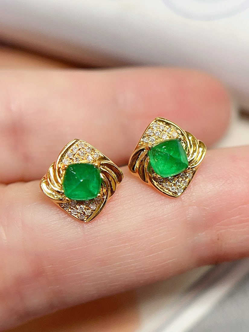 18K Gold Natural Emerald Earrings: Title: 18K Gold Natural Emerald Earrings Description: These earrings captivate with their elegant vintage design and the vibrant color reminiscent of a spicy green tart. The main stone is clean and fl