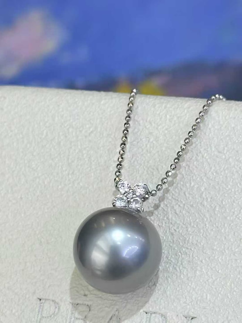 18K Gold Natural Tahitian Gray Pearl Pendant: Title: 18K Gold Natural Tahitian Gray Pearl Pendant Description: This pendant is meticulously crafted in 18K gold, featuring a natural Tahitian gray pearl that exudes understated luxury. The pearl mea