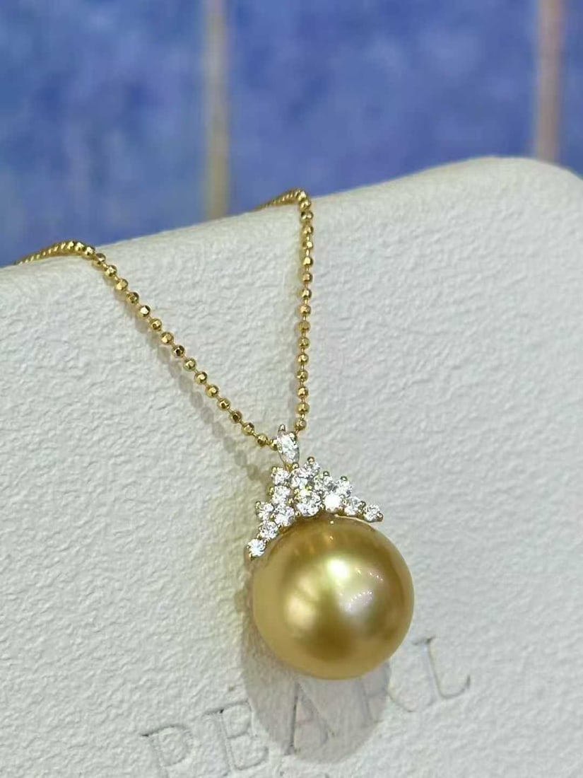 18K Gold Sea Water Pearl Pendant: Title: 18K Gold Sea Water Pearl Pendant Description: This 18K gold sea water pearl pendant features a pearl diameter of 11-12mm, perfectly accentuating the neckline with its warm golden luster, embody