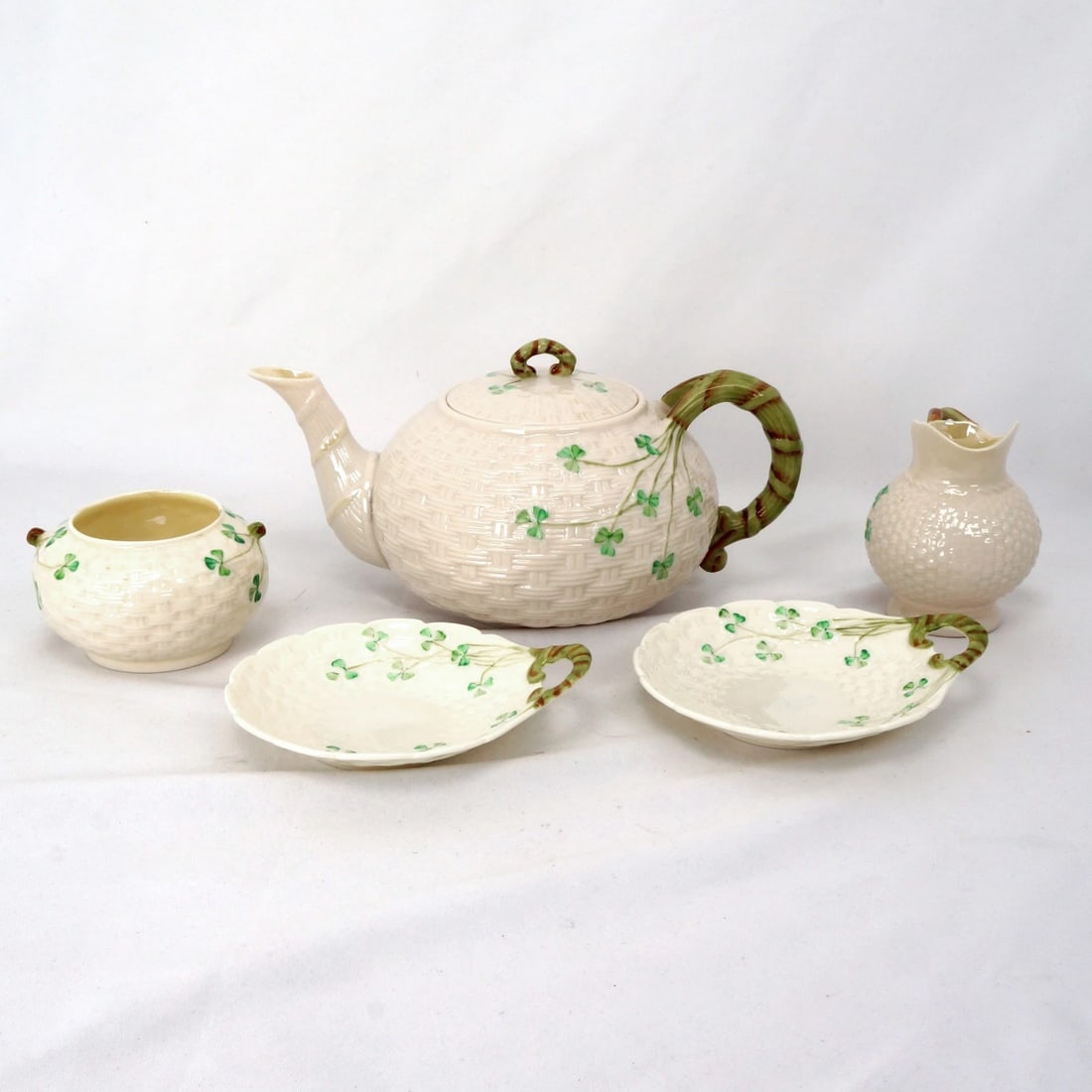 Belleek Shamrock Irish Tea Serving Set: Title:Belleek Shamrock Irish Tea Serving Set Size:Teapot – 9 1/2 in (24.1 cm) long x 6 in (15.2 cm) wide x 4 in (10.2 cm) tall Dishes – 5 1/4 in (13.3 cm) long x 4 5/8 in (11.7 cm) wide x 1 in