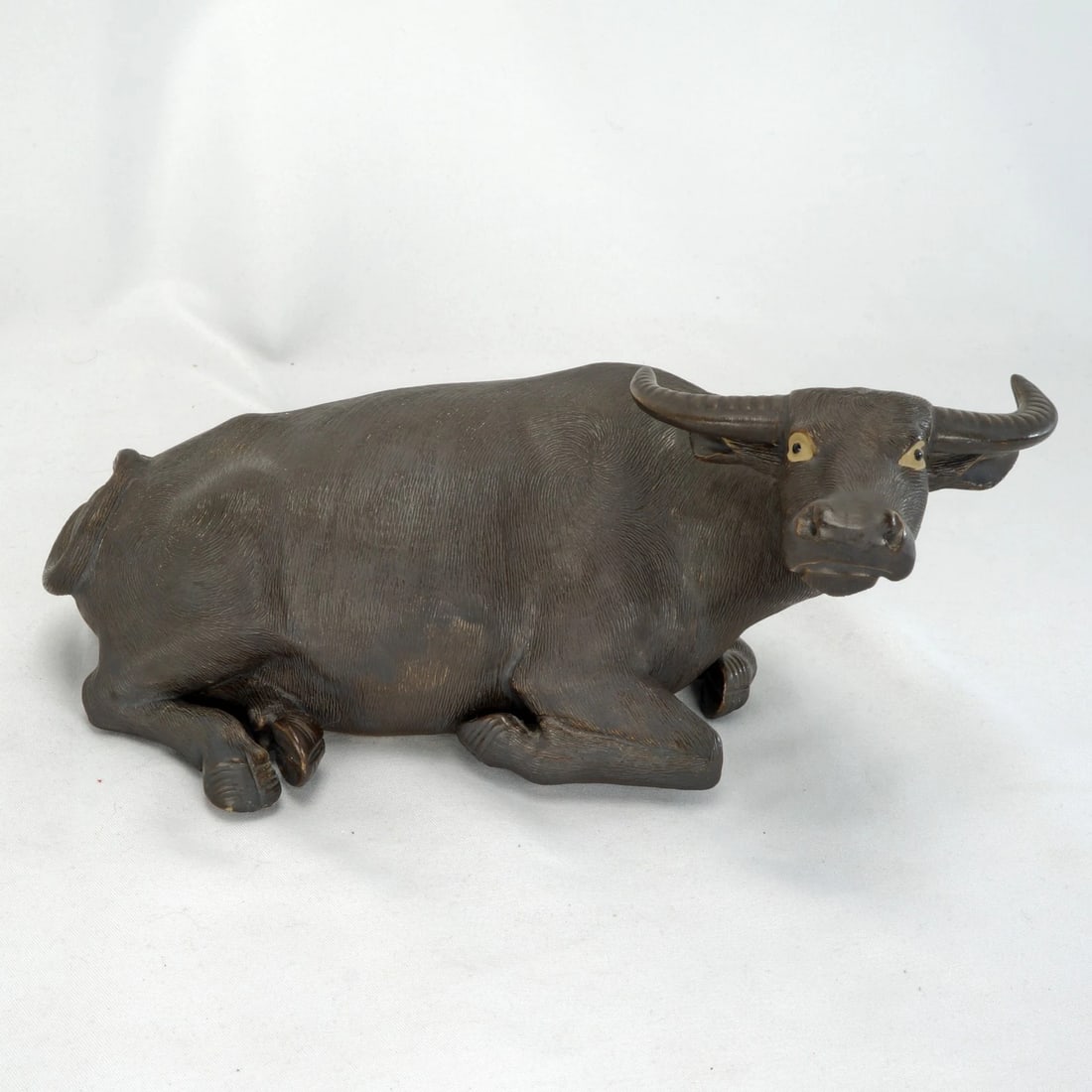 Chinese Shiwan Water Buffalo Republic Era: Title:Chinese Shiwan Water Buffalo Republic Era Size:8 ¾ in (22.2 cm) long x 6 in (15.2 cm) wide x 3 ¾ in (9.5 cm) tall. Description:An artistic, handmade sculpture of a recumbent water