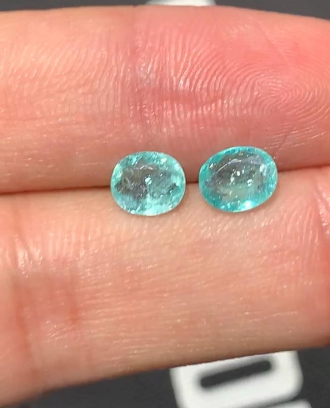 Oval Pair of Paraiba Tourmaline ~1.93 CT ~ AIGS Certified.: Tourmalinee Details: * Weight : 1.93 CT * Dimension : 1. 0.91 cts, = 7.41 x 6.10 x 2.62 mm 2. 1.02 cts, = 7.12 x 6.07 x 3.24 mm * Shape : Cushion Cut * Colour : Paraiba * Lustre: Vitreous * Certificat