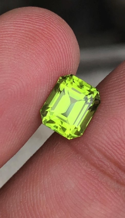 Apple Green Peridot Gemstone: 2.70 Carat Emerald Cut, Pakistan Origin: A Bright Green Peridot Loose Gemstone, boasting a Apple green hue in a faceted emerald cut. This 2.70 carat beauty is eye-clean and sourced from the renowned Sapat Mine, making it perfect for