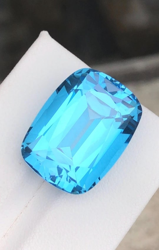 33.750 Carat Swiss Blue Topaz Gemstone: Cushion Cut December Birthstone: Introducing a magnificent Swiss Blue Topaz gemstone. Its long cushion shape, which sparkles wonderfully, stands for prosperity and love. This jewel is exquisitely carved and emanates grace and charm. 