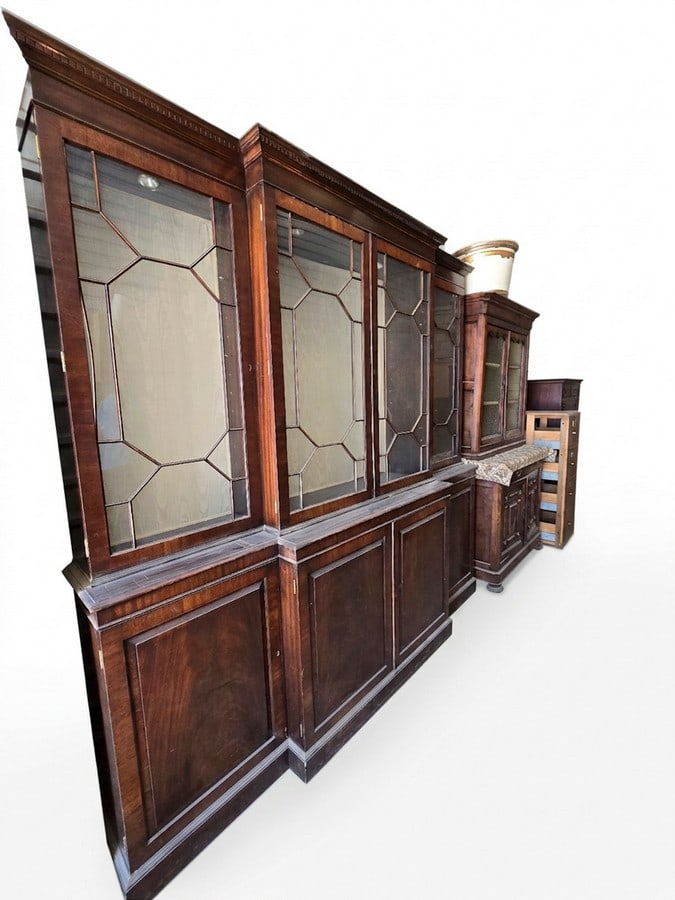 Large Georgian Style Breakfront Display Cabinet: A large breakfront display cabinet in the Georgian style, constructed from rich mahogany or similar dark wood. The upper section features three glazed doors with geometric mullions, opening to shelved