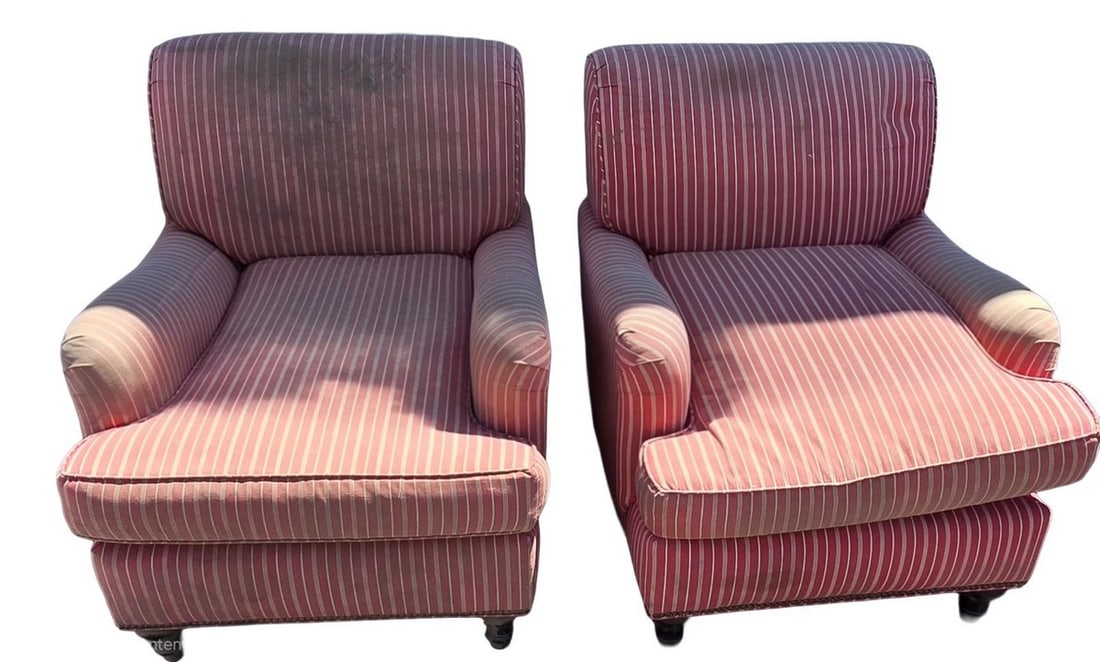 Pair of Upholstered Armchairs: A pair of matching upholstered armchairs with a red and white striped pattern. Each chair features rolled arms, a loose seat cushion, and dark turned wood feet. The fabric shows significant wear and