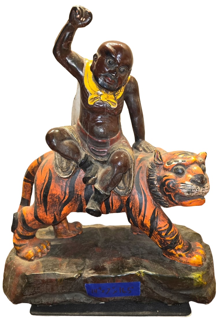 Vintage Hand-Carved and Painted Wood Figure of Man Riding Tiger: A vintage hand-carved and painted wooden sculpture depicting a figure, possibly a deity or warrior, riding a tiger. The figure is dark-skinned with a yellow scarf or adornment, and the tiger is