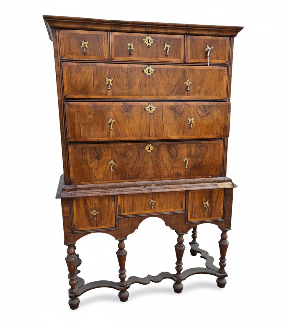 18th Century Baroque Walnut Chest-on-Stand: An 18th-century Baroque walnut chest-on-stand, featuring a chest of drawers with two small drawers over three graduated long drawers, all with ornate brass escutcheons and pulls. The chest sits on a