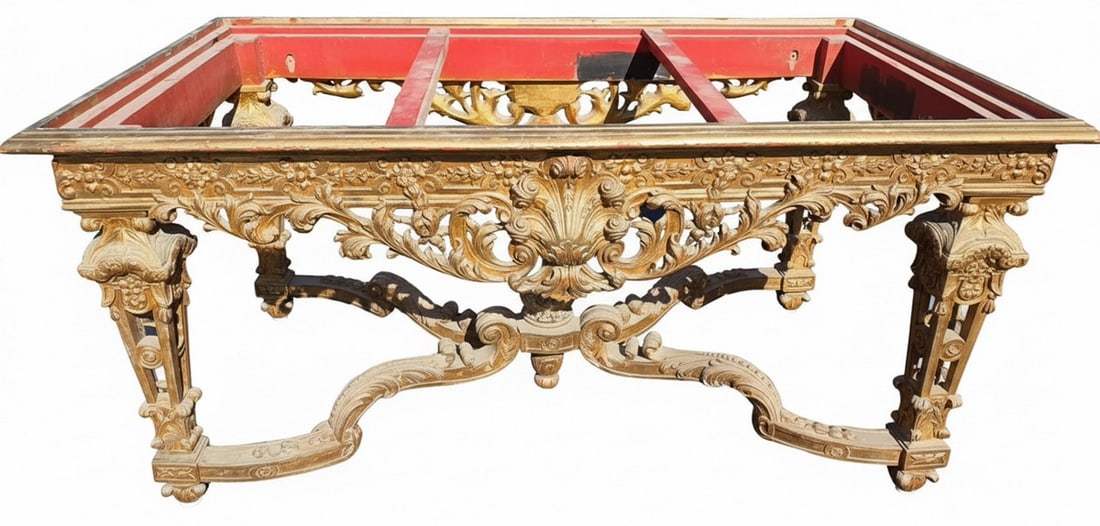 Heavily Carved Giltwood Table Frame: This ornate table frame features extensive rococo-style carving throughout, including scrolling acanthus leaves, C-scrolls, and shell motifs. The frame is constructed of wood with a gilt finish,