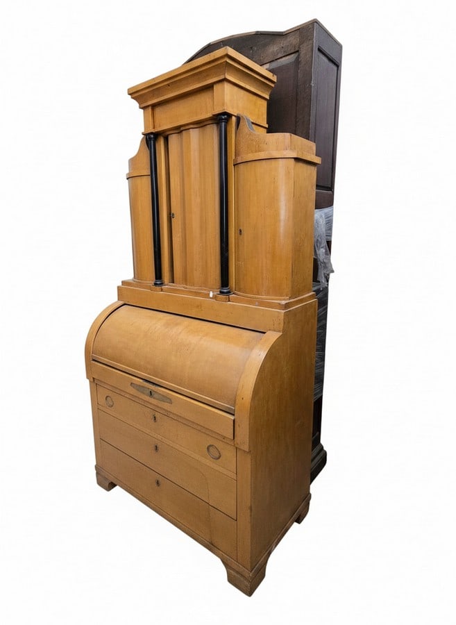 Biedermeier Style Birchwood Cylinder Desk Secretaire: An antique Biedermeier style birchwood cylinder desk secretaire. The upper cabinet features a pediment top, fluted columns, and three cabinet doors. The lower section has a roll-top cylinder desk, a c