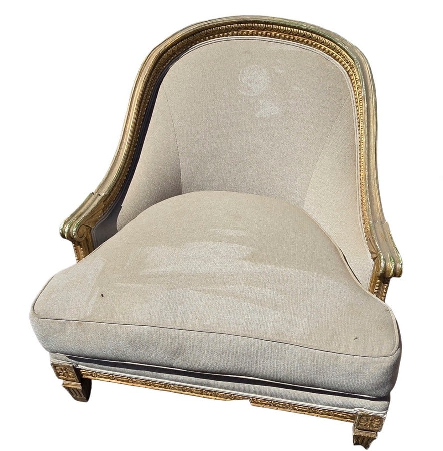 Giltwood and Upholstered French Bergere Armchair: An elegant French-style bergere armchair featuring a beautifully carved giltwood frame with classical motifs and upholstered in a light, neutral fabric. The frame shows remnants of green