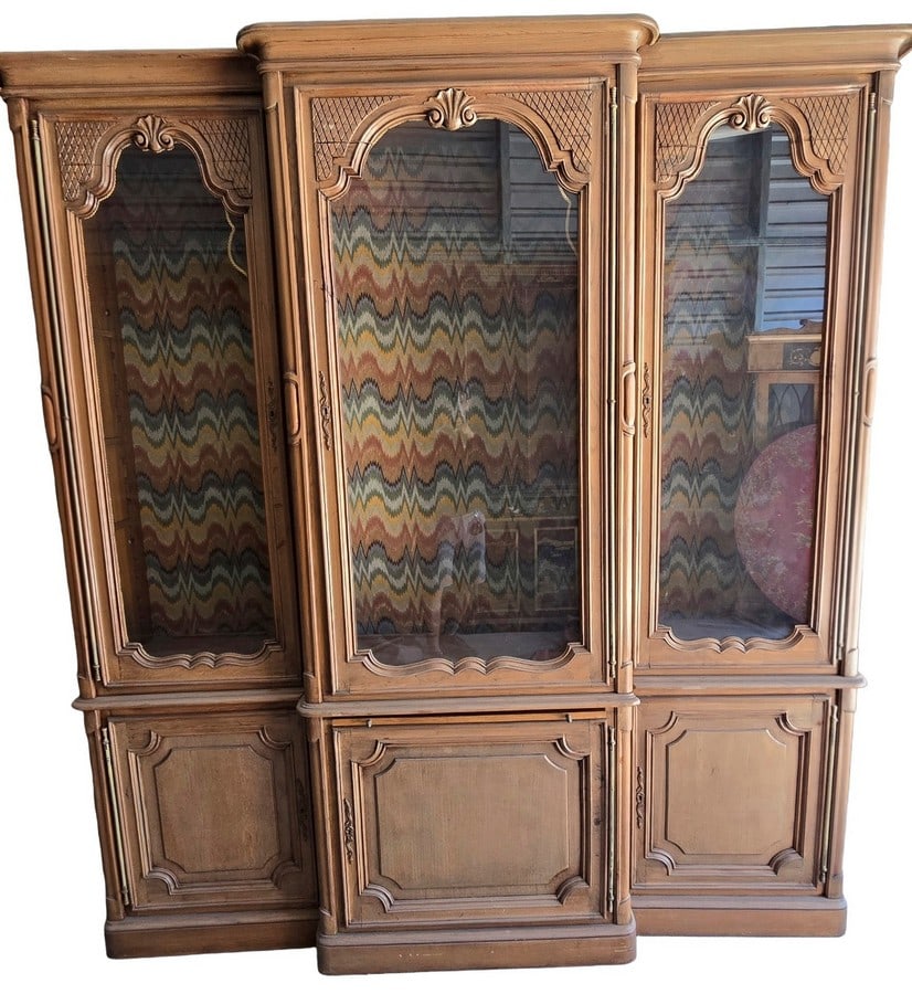 French Provincial Style Triple Curio Display Cabinet: A large French Provincial style triple curio display cabinet, likely from the mid to late 20th century. Constructed from light-toned wood, possibly oak or pecan, with carved details and a distressed f