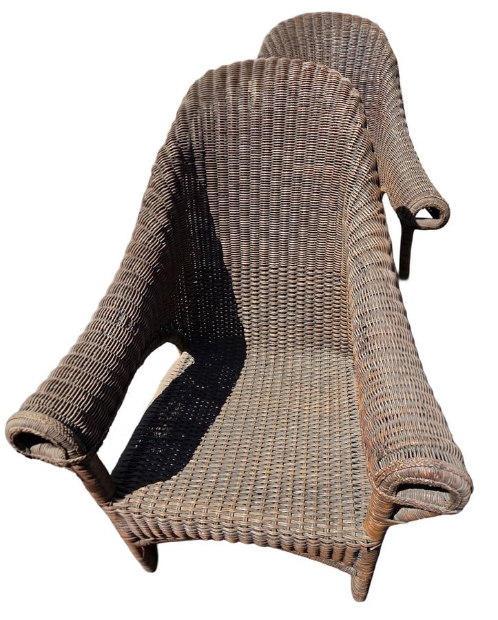 Pair of Woven Wicker Armchairs: A pair of contemporary woven wicker armchairs. Each chair features a curved back and armrests, with tightly woven brown wicker over a sturdy frame. Suitable for indoor or outdoor use, adding a