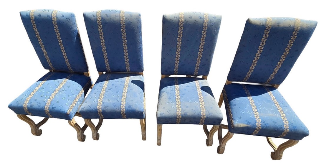 Set of Four Louis XVI Style Dining Chairs with Blue and Gold Upholstery: A set of four Louis XVI style dining chairs, featuring carved frames with a distressed finish and upholstered in a blue fabric with a gold floral stripe pattern. The chairs have elegant curved legs an