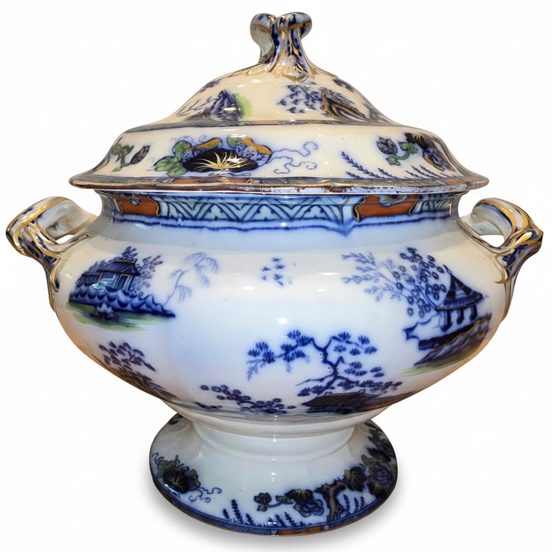 Antique Blue and White Transferware Soup Tureen with Underplate: An antique blue and white transferware soup tureen with an underplate, featuring an oriental landscape design with pagodas, trees, and floral motifs. The tureen has ornate handles with gilt accents.
