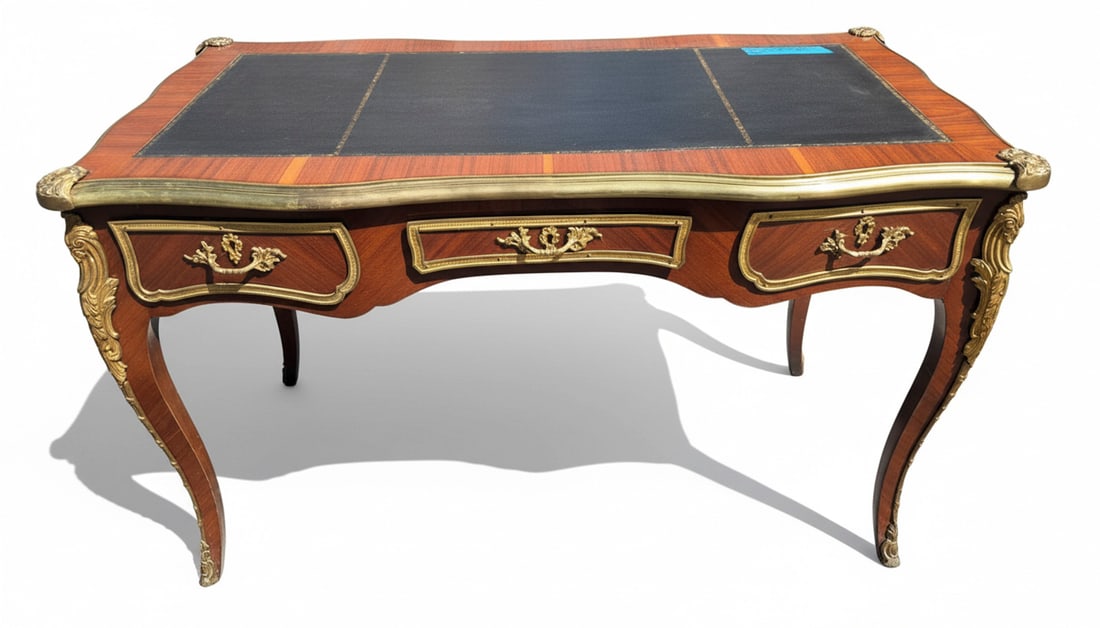Louis XV Style Gilt Bronze Mounted Kingwood and Leather Top Bureau Plat: This elegant bureau plat, in the Louis XV style, features a rich kingwood veneer with a parquetry top and a central gilt-tooled black leather writing surface. It is adorned with ornate gilt bronze mou