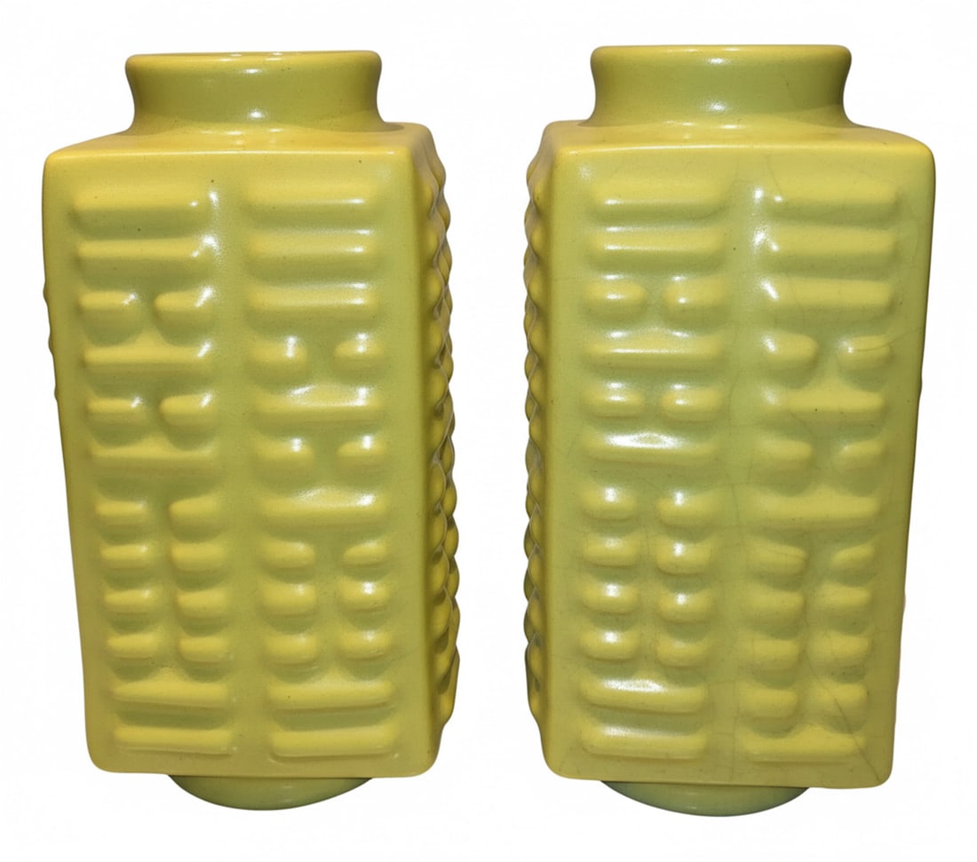 Pair of Chinese Yellow Glazed Relief-Decorated Vases: A pair of rectangular-form vases with vibrant yellow glaze and relief decoration of repeating geometric patterns. The bases bear blue underglaze marks reading "Kangxi Nian Zhi"