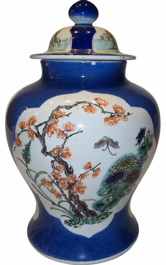 Large Japanese Imari Ware Lidded Urn / Vase: This vibrant, large Japanese Imari ware lidded urn or vase features a classic cobalt blue ground with reserves painted in polychrome enamels depicting flowering branches, insects, and varied flora. Th