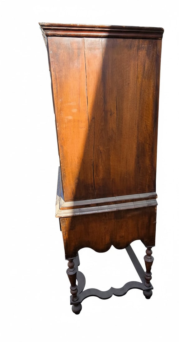 Antique Carved Wood Cabinet on Stand: This is an antique carved wood cabinet with a rich, dark finish. It features a decorative molded cornice, paneled sides, and stands on a separate carved base with turned legs and a curvilinear