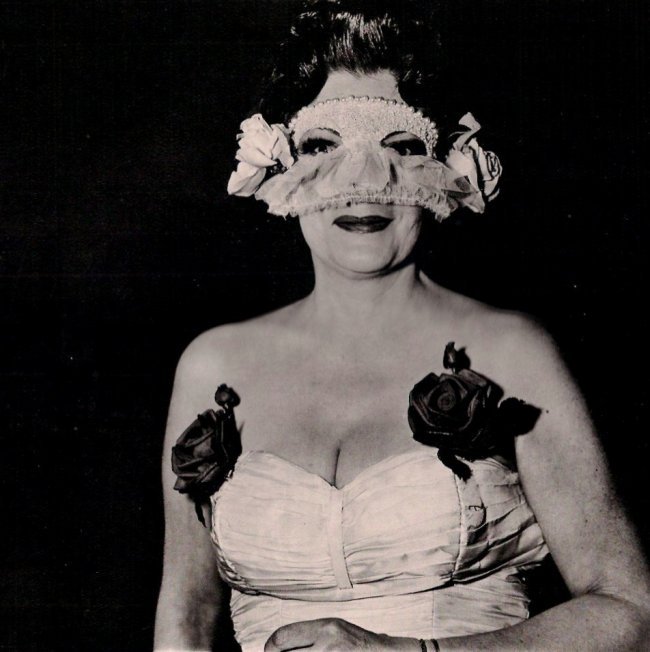 Diane Arbus: Lady at Masked Ball with Rose, NY 1967: Medium: Heliogravure with tissue guard Printed in Italy Date: 1979 Paper Size: 15 3/4 x 11 5/8 inches Image Size: 9 7/8 x 10 inches Diane Arbus was an American photographer often regarded as one of th