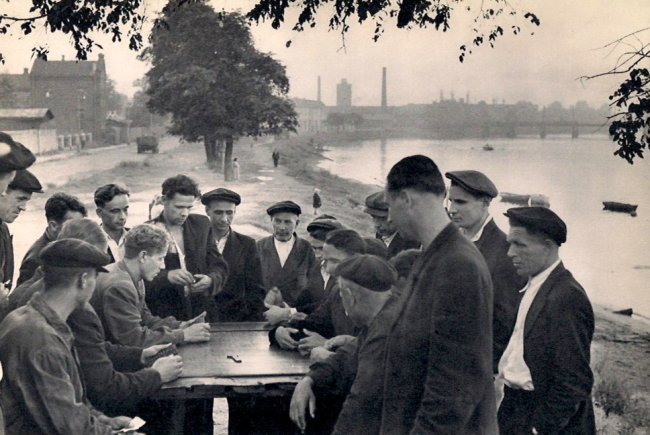 Cartier-Bresson: Dominoes in the Suburbs of Leningrad: Medium: Sheet-fed Copper Plate Gravure Date: 1955 Printer: Draeger Freres, France Image Size: 9 x 6 inches Henri Cartier-Bresson was a French photographer who specialized in humanist photography. He i