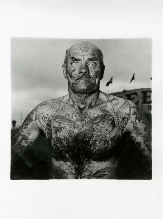 Diane Arbus: A Tattooed Man at Carnival, MD: Title: A Tattooed Man at Carnival, MD Artist: Diane Arbus Medium: Heliogravure with tissue guard Date: 1979 Origin: Italy Paper Size: 15 3/4 x 11 5/8 in Image Size: 9 7/8 x 10 inches Diane Arbus was a