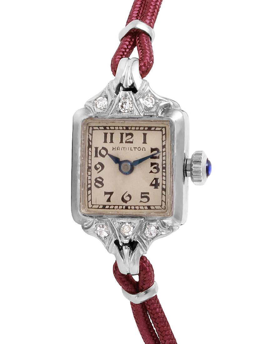Hamilton 14K White Gold Silk Cord Watch: Domestic: Free Shipping Watch: Antique Hamilton 14K White Gold Watch Bracelet: Reddish toned silk cord, 6 inches Clasp: Gold filled clasp Dial: Off white face wtith blackish brown numerals and blue ma