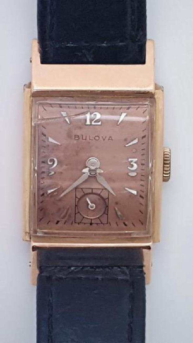 Vintage Bulova 14K Rose Gold Filled Men's Watch: Watch: Vintage Bulova 14K Rose Gold Filled Art Deco Men's Watch Movement: Mechanical winding Dial: Arabic & Stick square salmon dial Bracelet: Black leather strap Size: 9 inches long Total Weight: 20.