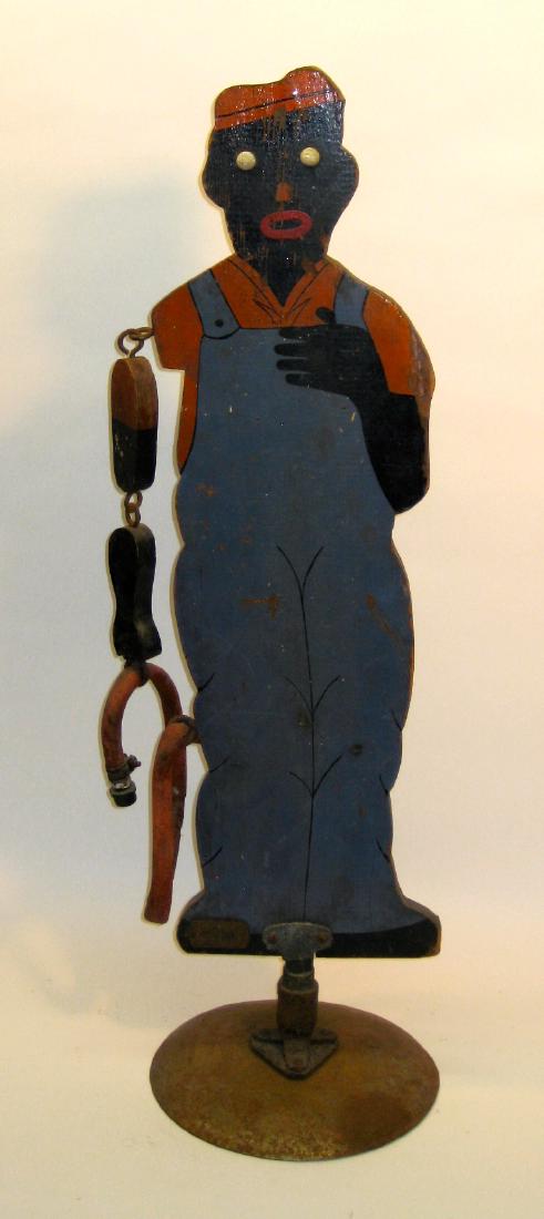 Sprinklin' Sambo Wood Lawn Sprinkler: Item: Sprinklin' Sambo Wood Lawn Sprinkler Materials: Wood, Rubber, Metal base Size: 34.5 inches tall x 10 inches diameter Description: When new the body rotates under pressure and the hose goes wild.