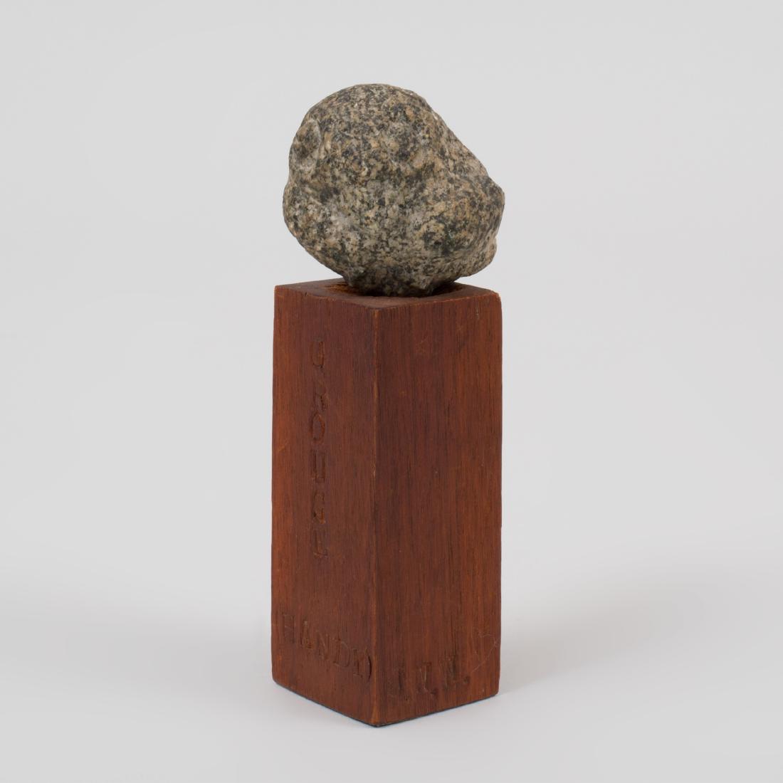 Small Carved Granite Figure of Bird on a Burnished Wood: The bird unsigned, the base stamped 'Grouse (Handy), J.W.W., 1961'. The bird 1 1/2 x 2 in., the base 3 1/8 x 1 1/2 x 1 1/2 in.