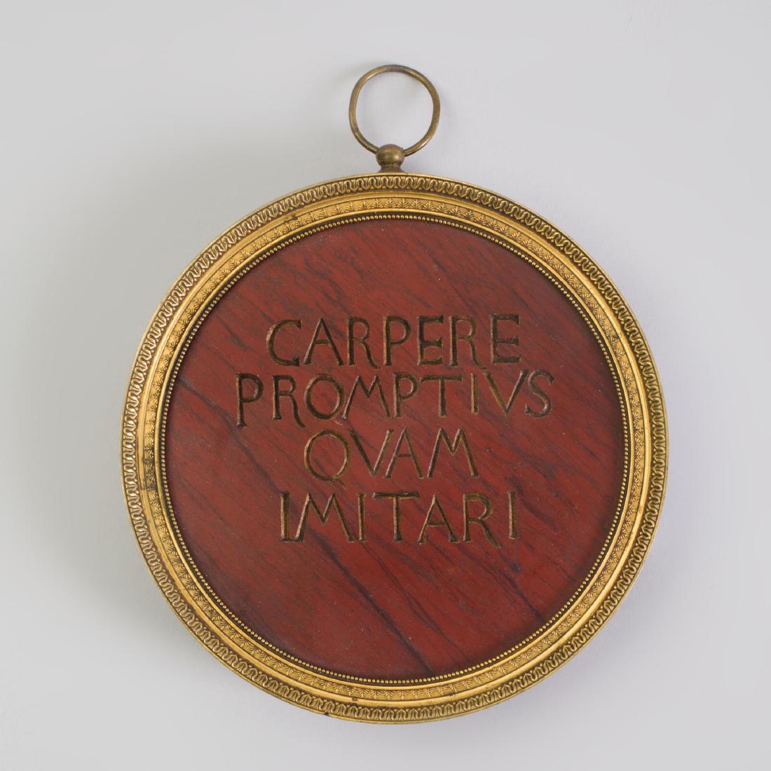 Italian Ormolu-Mounted Carved Red Marble Rondel: Italian Ormolu-Mounted Carved Red Marble Rondel Inscribed 'Carpere Promptius Ovam Imitari' within leaf-tip cast frame. 7/8 in. x 5 1/2 in. diam.