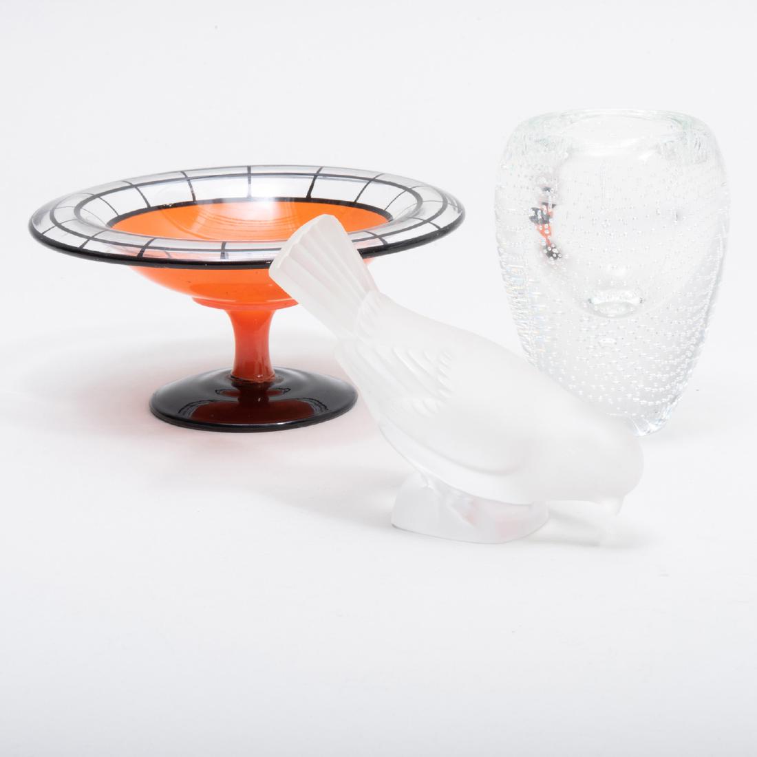 Three Modern Glass Table Articles: Three Modern Glass Table Articles Comprising: A Lalique model of a bird, signed in etch A Josh Simpson paperweight vase, signed in etch An Art Deco style tazza The bird 5 1/4 in. long.