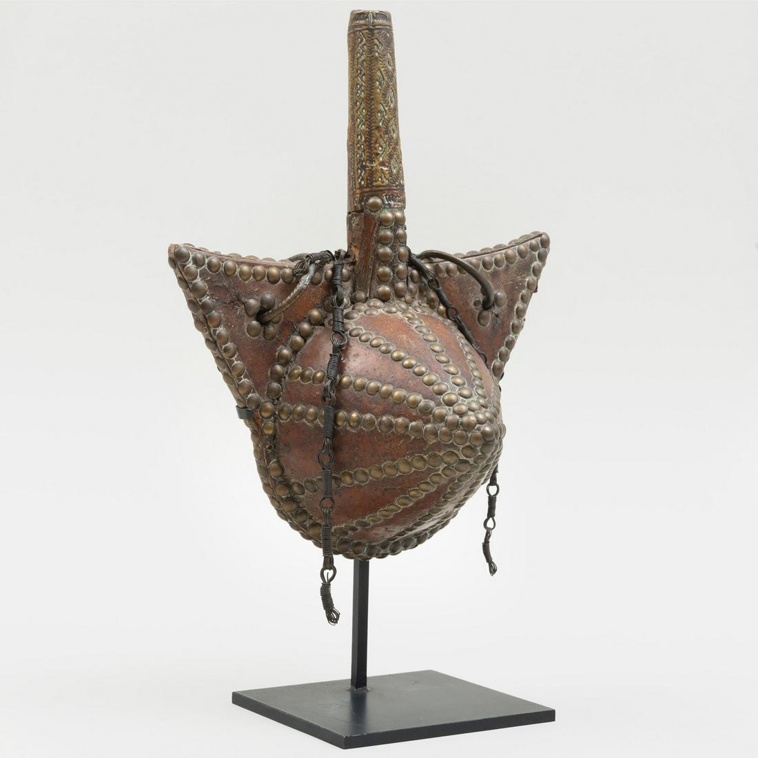 Moroccan Brass Studded Leather Powder Flask: Moroccan Brass Studded Leather Powder Flask Raised on a stand. 12 x 9 3/4 x 4 1/2 in. Note: A nearly identical Moroccan Powder Flask is illustrated in Marc Ginzberg, African Forms, Skira, 2000, page 6