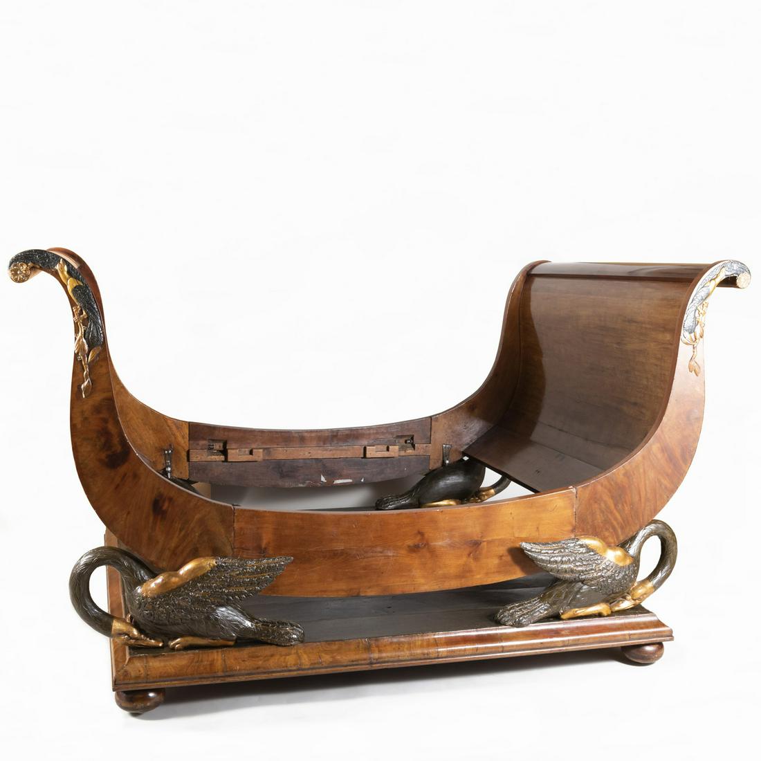 Unusual Empire Mahogany Painted and Parcel-Gilt Sleigh: Unusual Empire Mahogany Painted and Parcel-Gilt Sleigh Bed Mounted on an ebonized platform with flat bun feet, the sides fitted with swans, the bed terminating in scrolled ends. Overall: 51 x 90 x 65